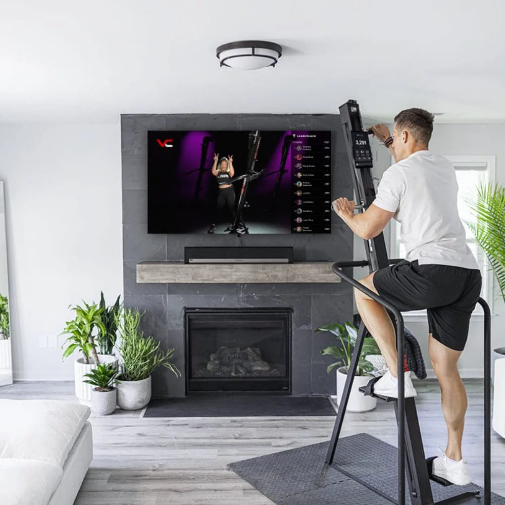 VersaClimber Home – woman finishing workout on vertical climber showing compact design in home gym