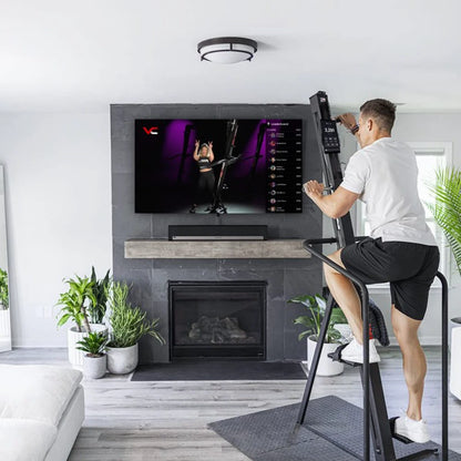 VersaClimber Home – woman finishing workout on vertical climber showing compact design in home gym