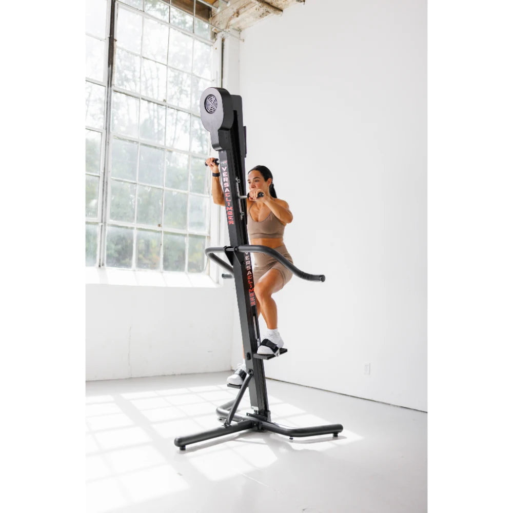 VersaClimber TS Magnetic – lifestyle photo of athlete finishing a climb on black vertical cardio machine in bright studio