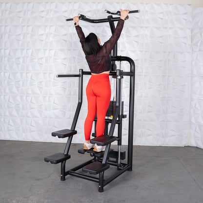 Woman in red leggings using a black pull-up machine in a gym.
