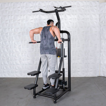 Man exercising on a black dip station with weight stack, wearing gray tank top and sweatpants.