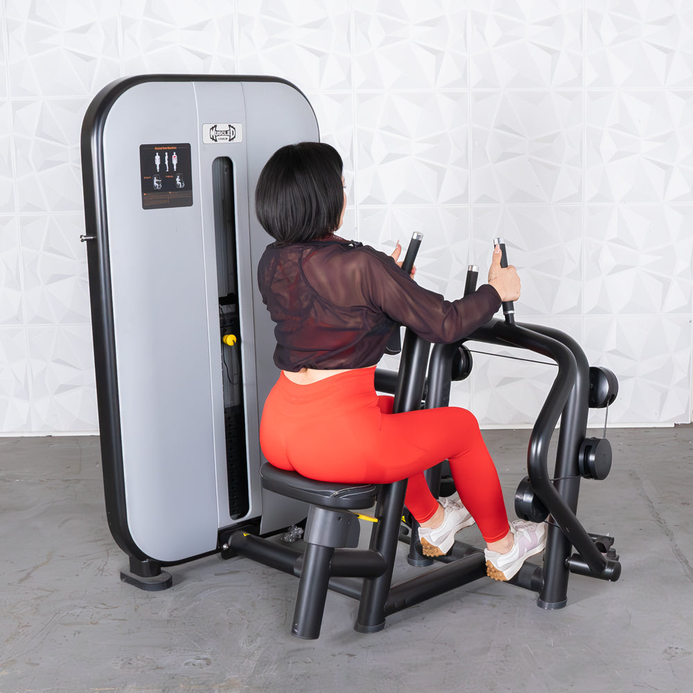 Woman using a seated row machine in bright red leggings for strength training.