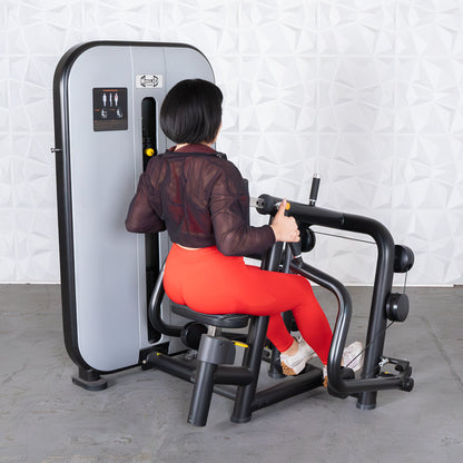 Woman using a seated row machine in red leggings for back exercise.