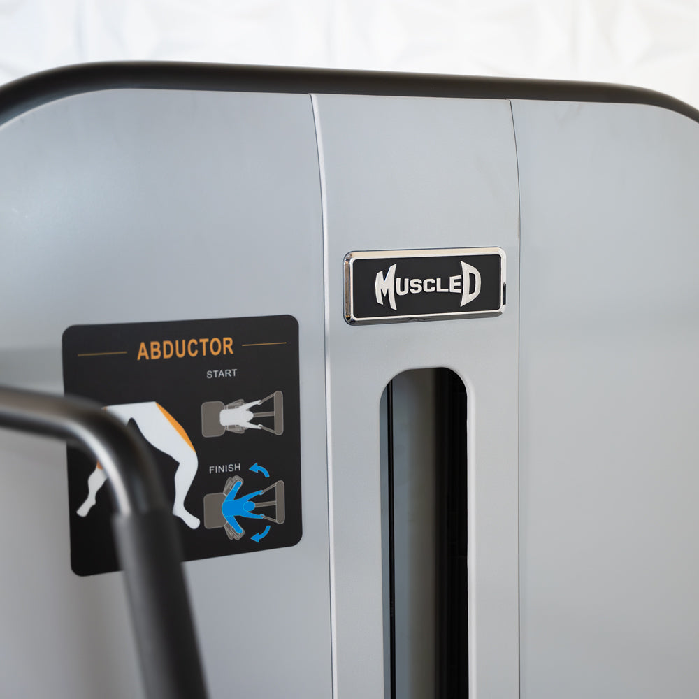 Close-up of a MuscleD abductor machine panel with start/finish diagrams.