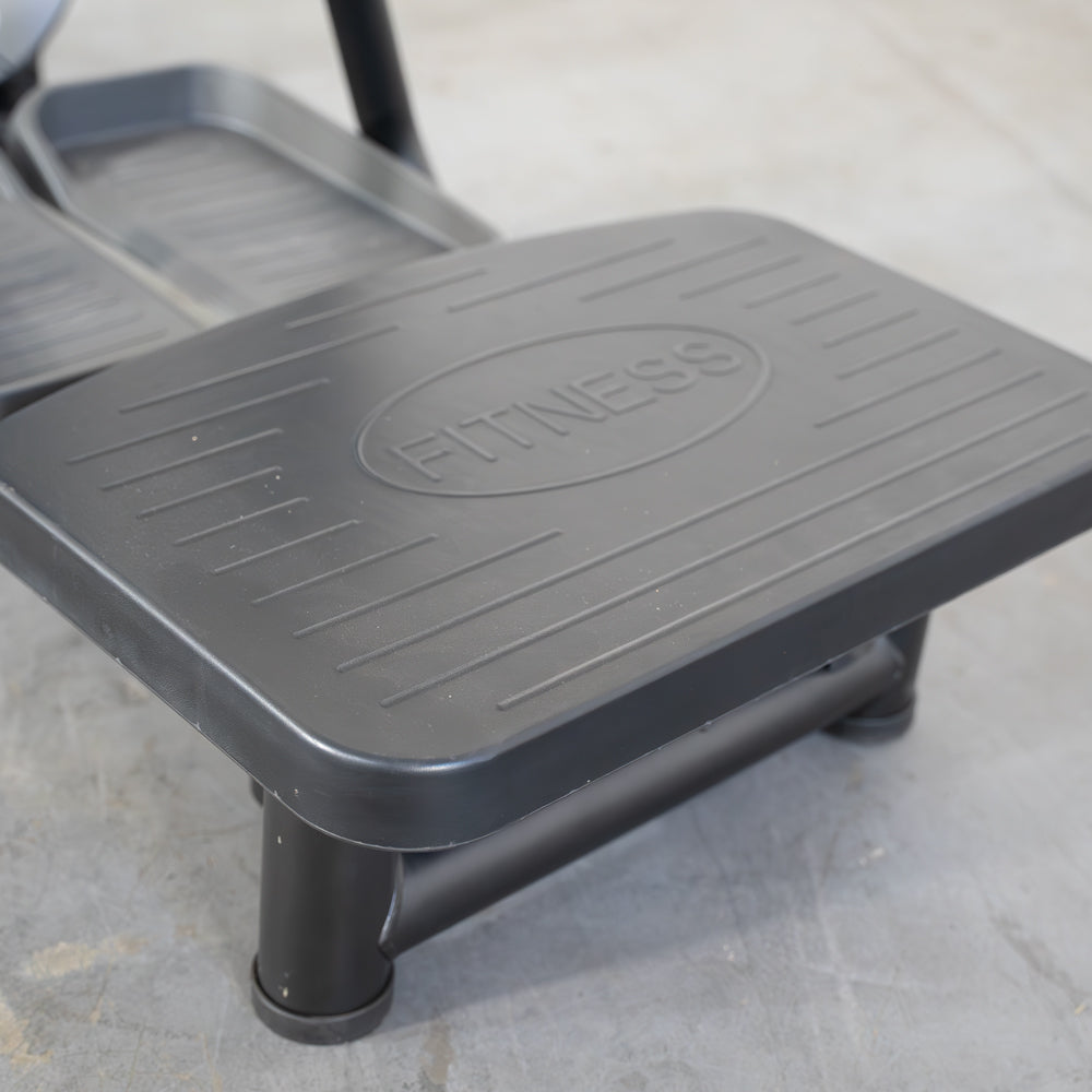Black fitness step platform with ribbed surface for workouts.