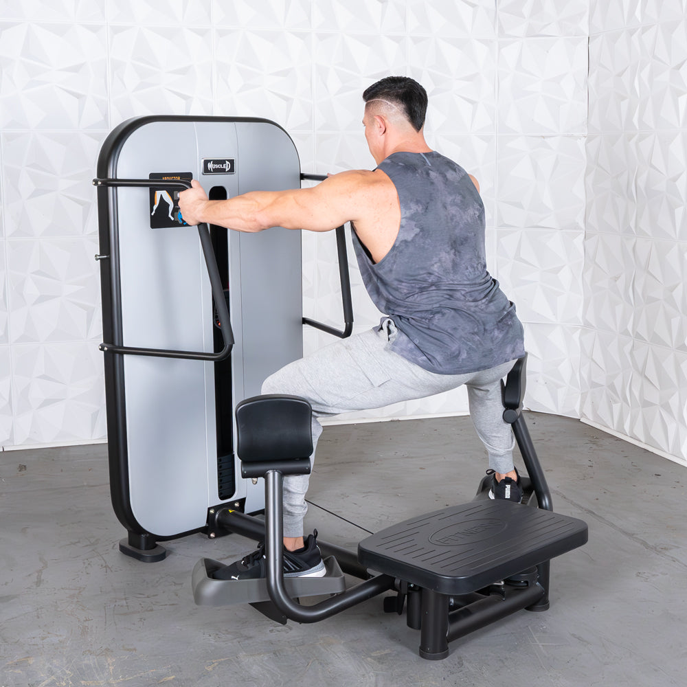 Man using standing abductor exercise machine at gym