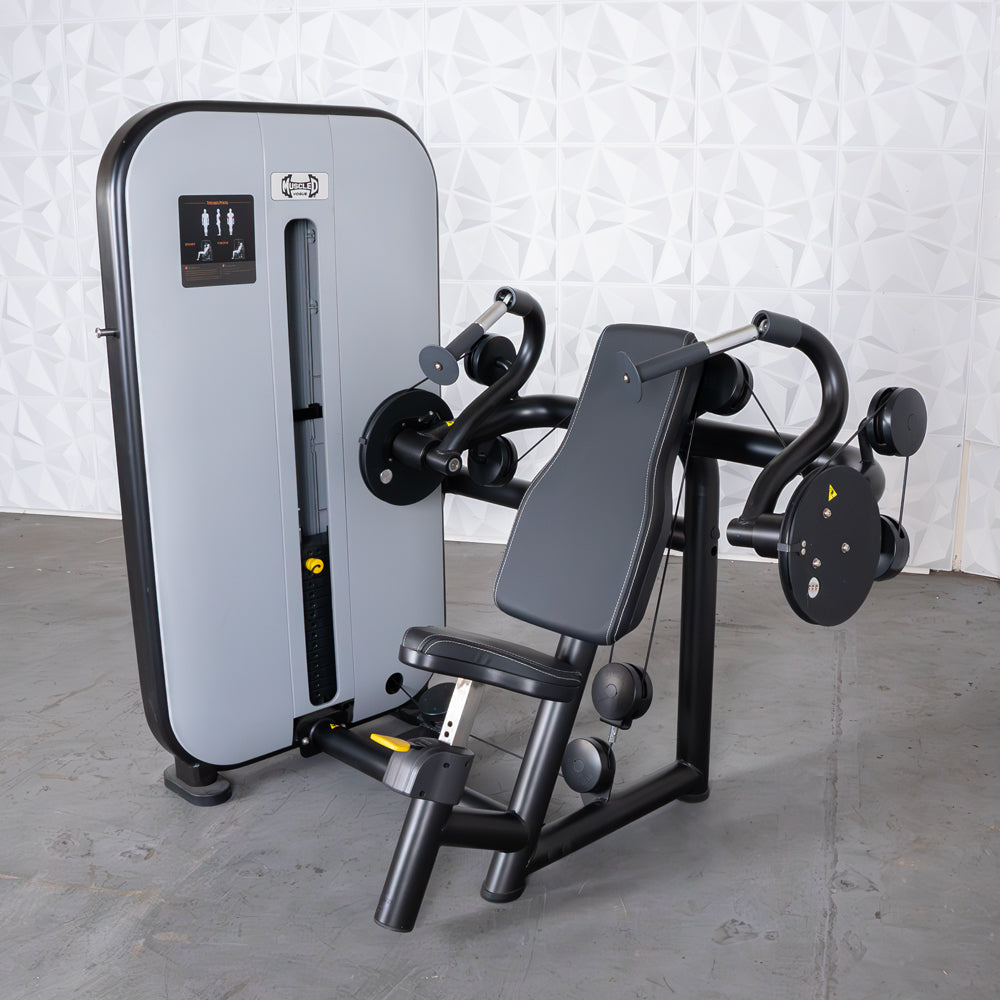 Gym weight machine for triceps extension with padded seat and handles.