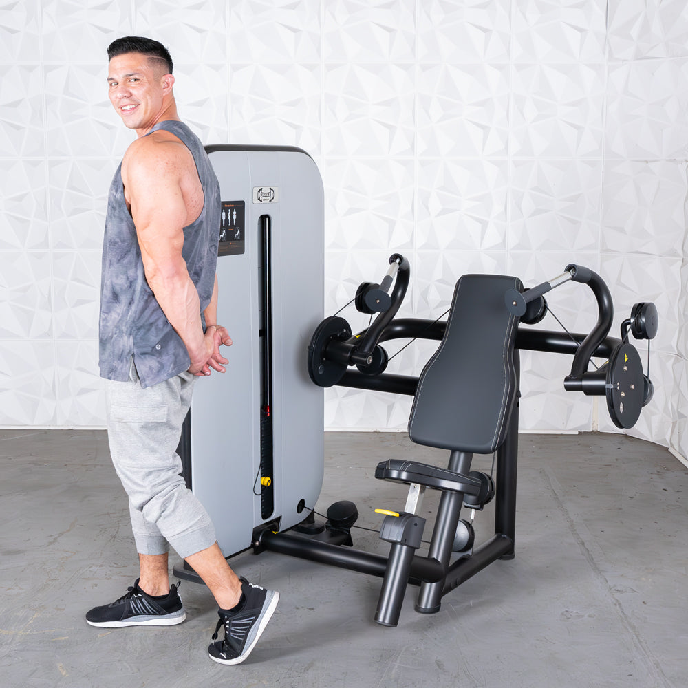 Man at gym using a seated triceps extension machine.