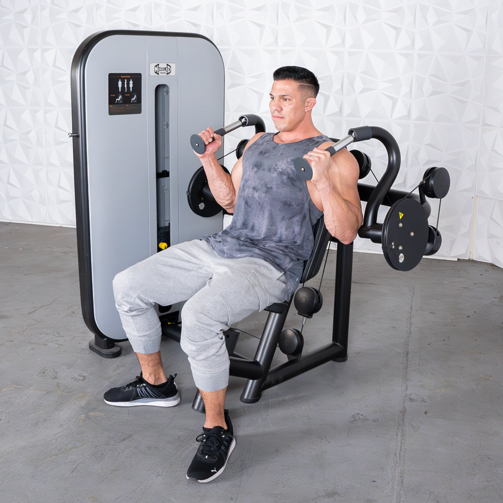 Man using a seated triceps extension machine at the gym.