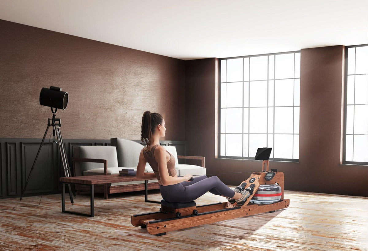 Woman exercising on a wooden rowing machine in a modern living room with large windows.