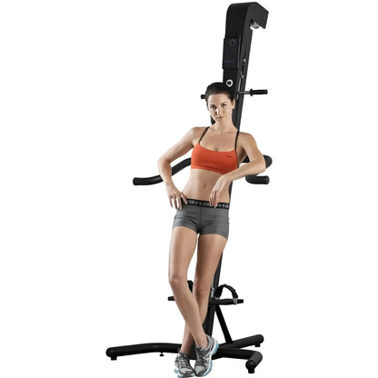 VersaClimber TS Magnetic – woman standing in front of black climber illustrating equipment height and ergonomic handles