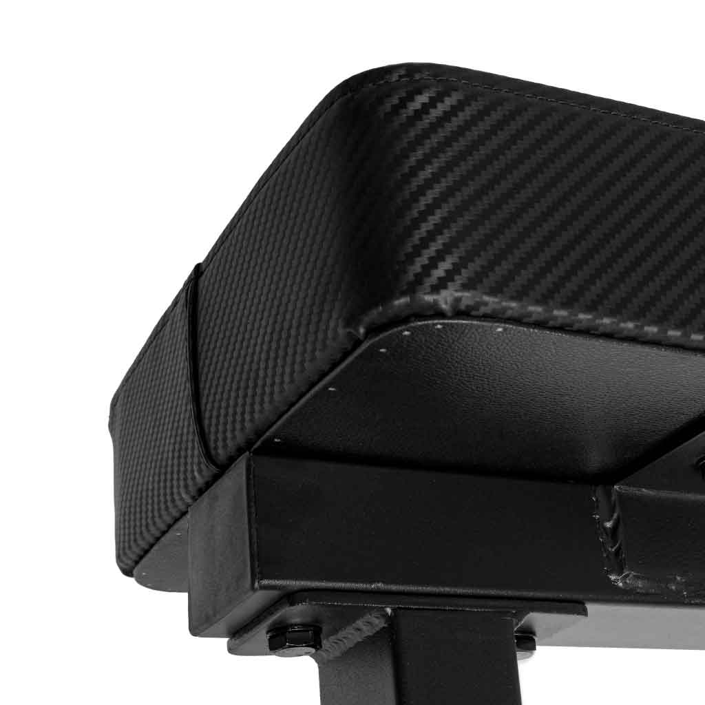 Close-up of a black bench underside with carbon-fiber texture and metal frame.
