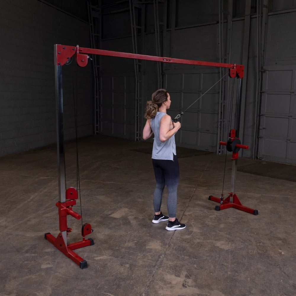 A woman performing a cable exercise on a red cable machine in a gym setting, demonstrating strength training.