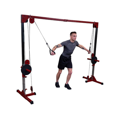 A young man with tattoos performing an exercise using a cable machine in a gym setting, showcasing strength training.