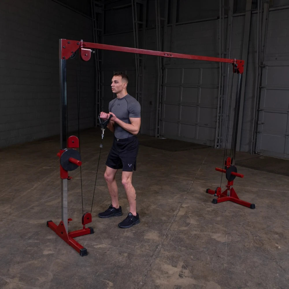 A man in athletic wear performing an exercise with a cable machine in a gym setting, focusing on strength training.