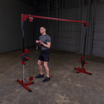 A man in athletic wear performing an exercise with a cable machine in a gym setting, focusing on strength training.