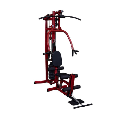 A red multi-gym workout machine with a bench, pulleys, and weights, designed for strength training exercises.