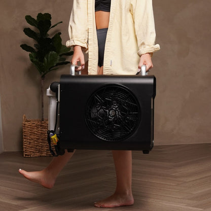 A person carrying the Coldture Water Chiller Pro, featuring a large fan on the side, in a stylish indoor setting.