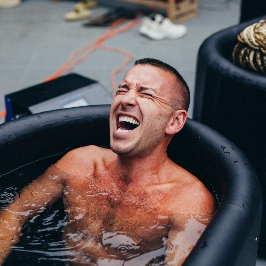 A man enjoying a cold plunge in a tub, showcasing the Coldture Classic + Chiller Pro equipment.