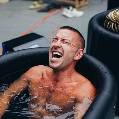 A man enjoying a cold plunge in a tub, showcasing the Coldture Classic + Chiller Pro equipment.