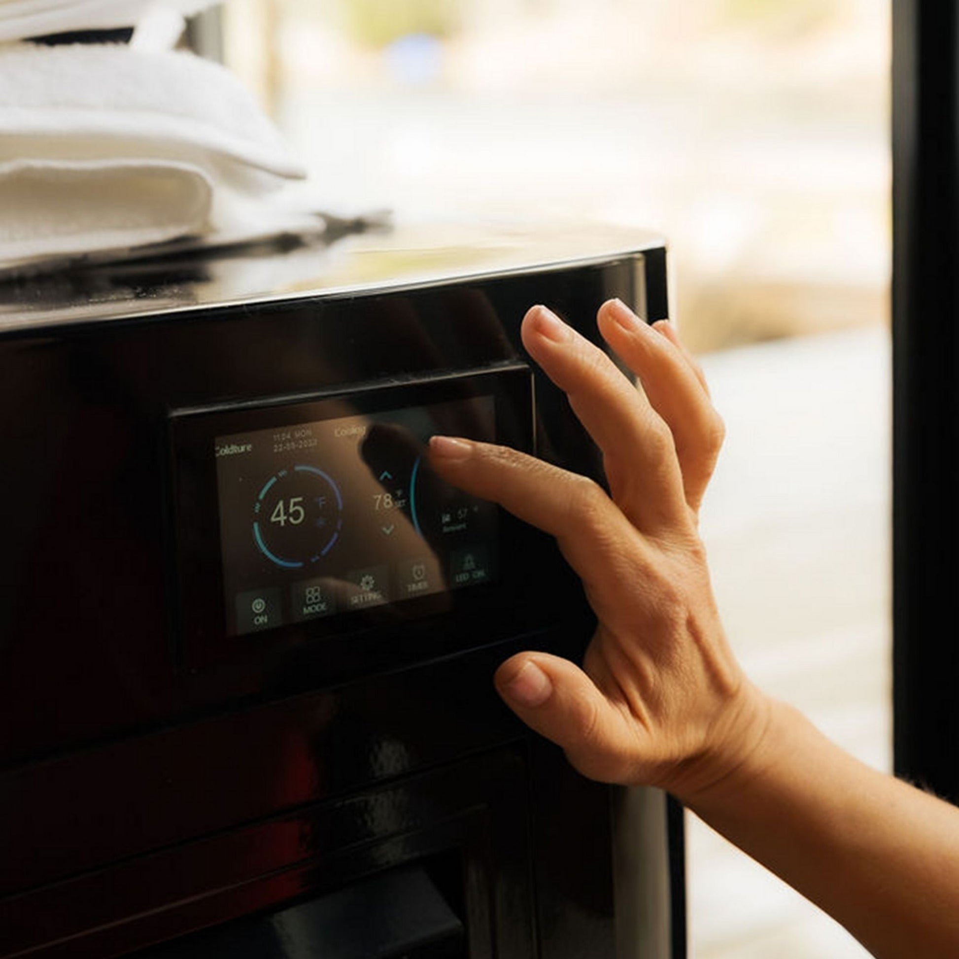 A hand interacting with the touchscreen display of the Coldture Pro Plunge, showing temperature settings of 45°F and 78°F.