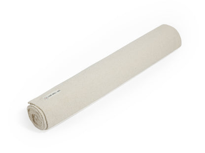 Beige cotton yoga mat rolled up.