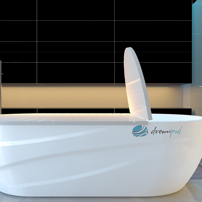 Dreampod Home Float Pro, a sleek white floatation pod with a partially open lid, set against a modern black tiled background.