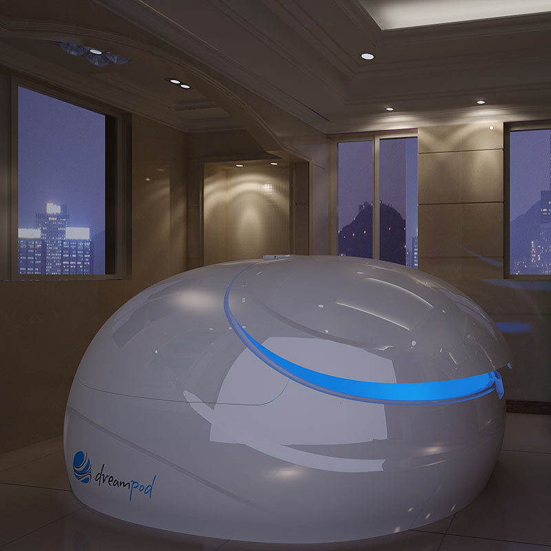 Dreampod V2 Float Pod in a modern, softly lit room with large windows showcasing a cityscape at night.