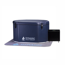 A round, navy blue cold therapy tub with the text DYNAMIC COLD THERAPY on its side, accompanied by a small black cooling unit, all placed on a matching mat.