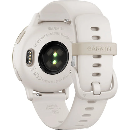 Close-up view of the back of a Garmin Venu 5 smartwatch, featuring a light sensor and charging contacts, with a beige silicone strap and quick release mechanism.