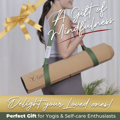Woman holding a cork yoga mat with green carrying strap, wearing gray activewear against a white background with gold gift bow and plant decoration.