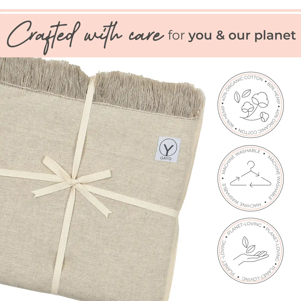 Cream-colored hemp and organic cotton yoga blanket with fringed edges, tied with a cream ribbon bow, displaying GAYO brand label and three circular icons indicating organic cotton, machine washable, and planet-loving materials.