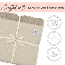 Cream-colored hemp and organic cotton yoga blanket with fringed edges, tied with a cream ribbon bow, displaying GAYO brand label and three circular icons indicating organic cotton, machine washable, and planet-loving materials.