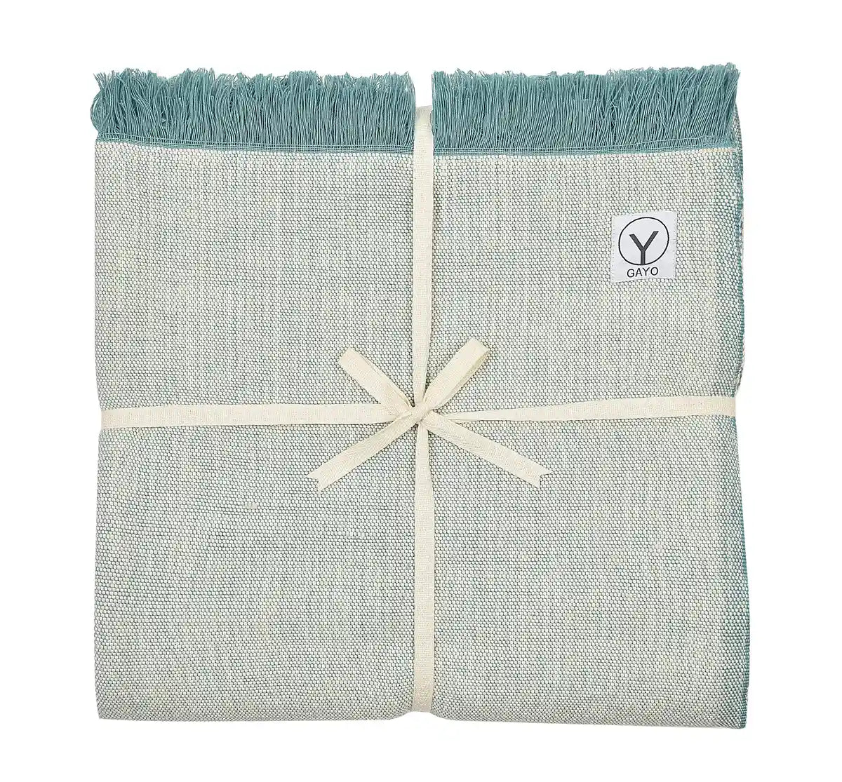 Organic cotton yoga blanket in light gray with teal fringe edges, tied with a cream ribbon and featuring a Gayo brand label.