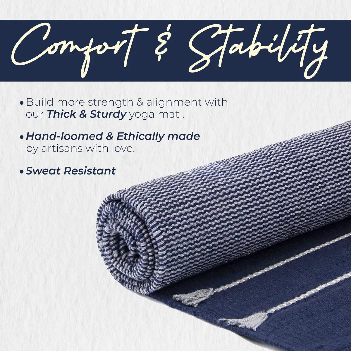 Rolled organic cotton yoga mat in gray and navy blue with textured surface and cream binding edges, displayed against a white background.