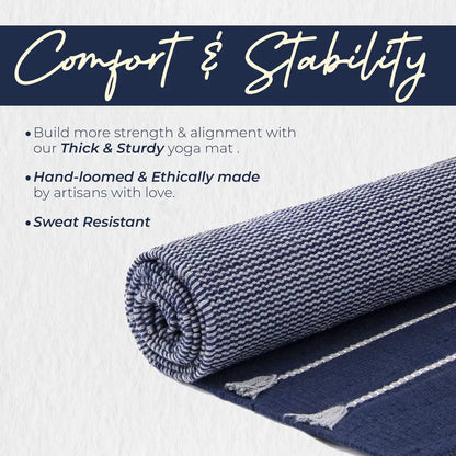 Rolled organic cotton yoga mat in gray and navy blue with textured surface and cream binding edges, displayed against a white background.