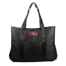 Black tote bag with two handles and a red logo patch.