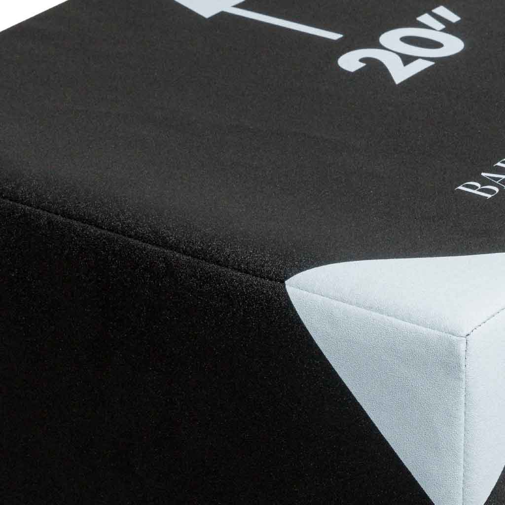 Close-up of a black jump box mat with a white corner seam.