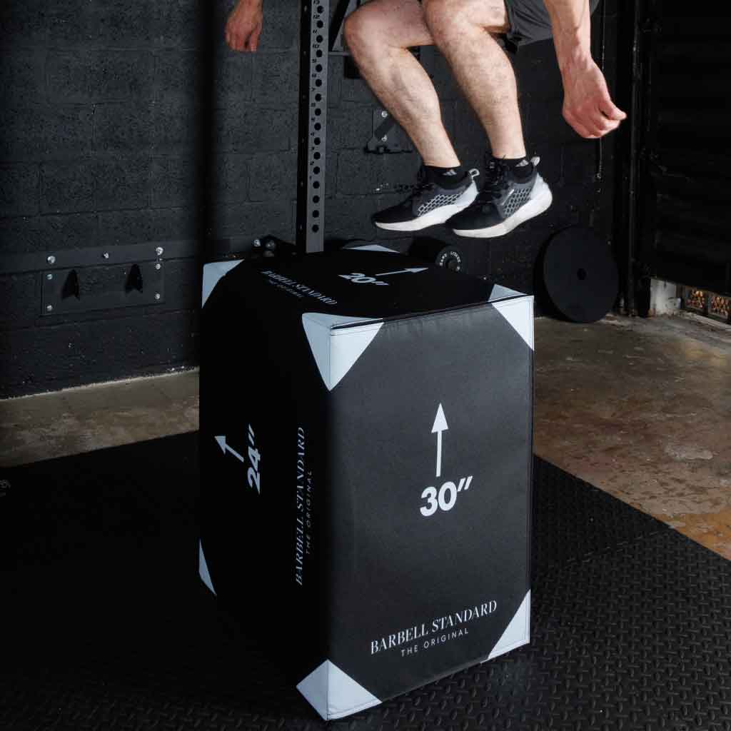Person mid-air while jumping onto a 30-inch jump box.