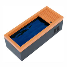 A modern rectangular swim spa with a wooden deck on one side, featuring deep blue water and a sleek design.