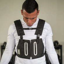 Man wearing a black weighted vest during a workout.