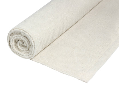 Rolled natural cotton yoga mat in beige.