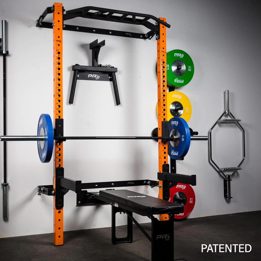 Orange PRX power rack with bench and weight plates in a gym.