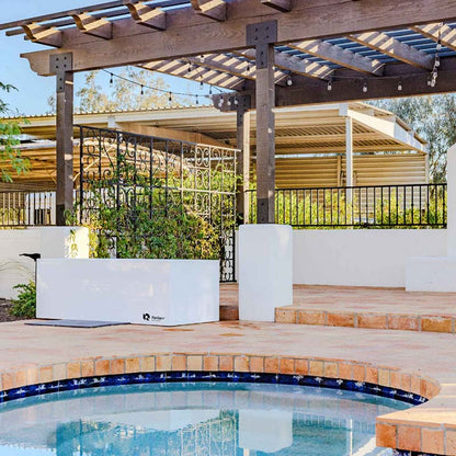 Modern outdoor space featuring a white Refined poolside storage unit and a wooden pergola.
