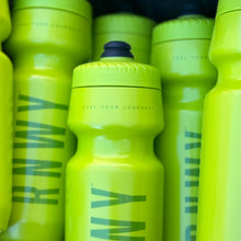 Neon yellow sports water bottles with textured grip and dark blue flip-top caps, featuring teal graphic design and "Fuel your journey" text on the center bottle.