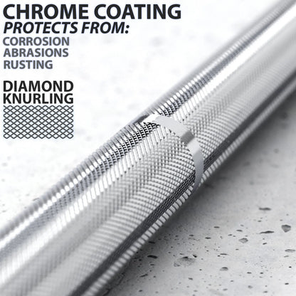 Chrome-coated barbell with diamond knurling grip pattern on the shaft, shown at an angle on a speckled gray surface.