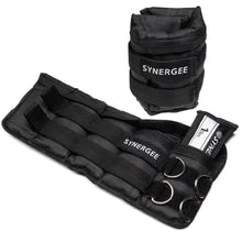 Black adjustable ankle and wrist weights set with Synergee branding, featuring padded neoprene construction, multiple D-ring attachment points, and a drawstring closure bag for storage.