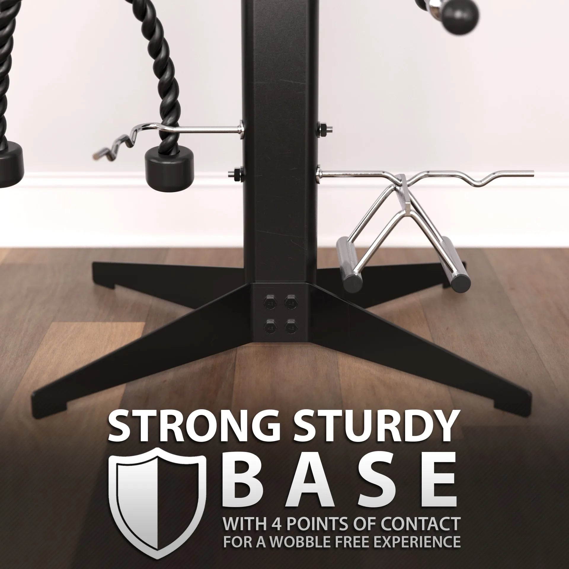 Cable attachment rack with black vertical post and four-point base, featuring multiple chrome bars and hooks for holding resistance bands and rope attachments on wooden flooring.