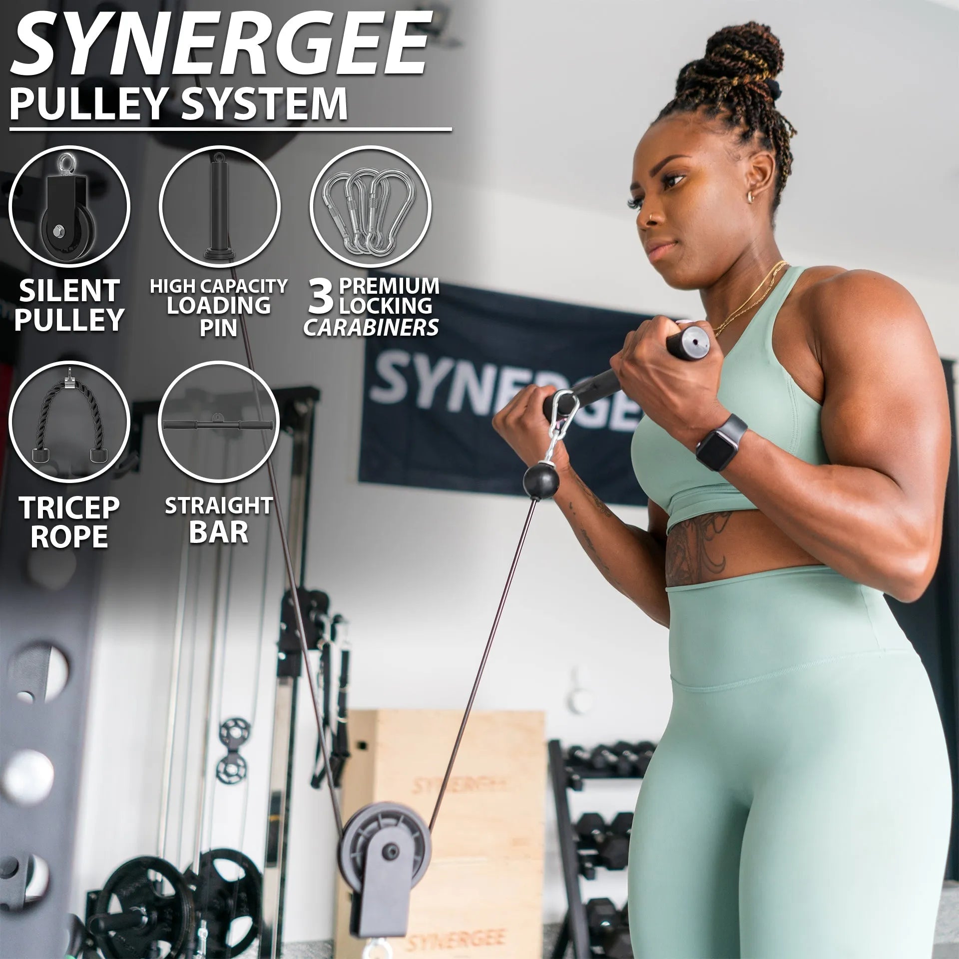 Woman performing a bicep curl exercise using a Synergee cable pulley system with a straight bar attachment in a home gym setting. Feature callouts show the silent pulley, high capacity loading pin, three locking carabiners, tricep rope, and straig...
