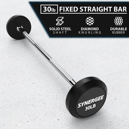 30lb fixed straight barbell with black rubber plates and solid steel shaft on white speckled surface. Product labeled "Synergee 30LB" with feature callouts for diamond knurling and durable rubber construction.